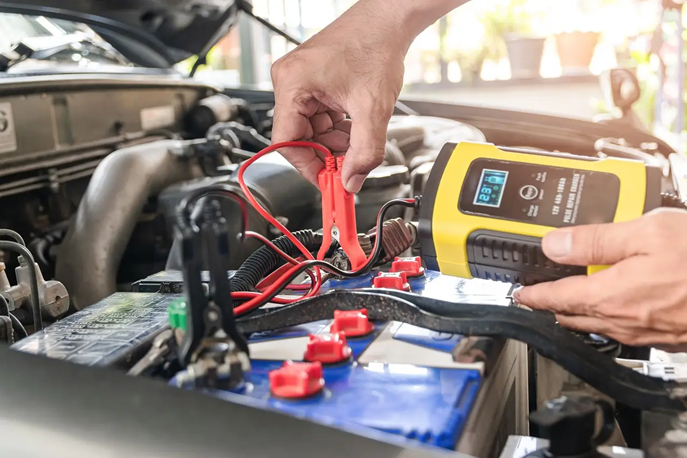 A mechanic tests a battery.