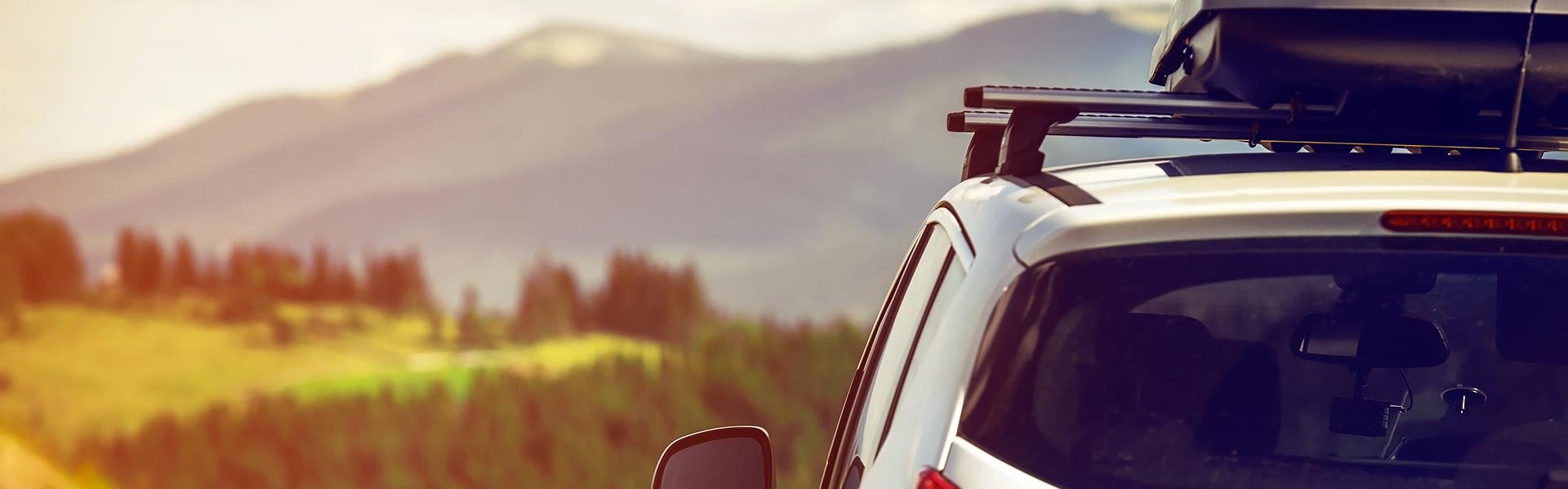 Side view of car with roof rack overlook a valley